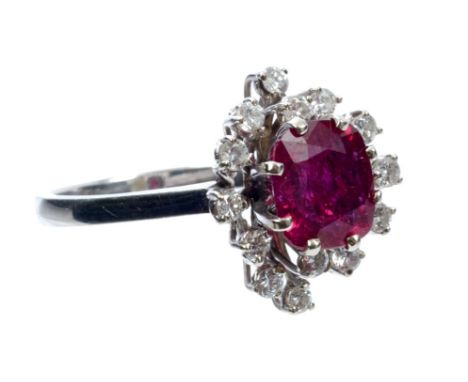 Ruby and diamond cocktail ring with a cushion-shape mixed cut ruby surrounded by an undulating border of fourteen brilliant c