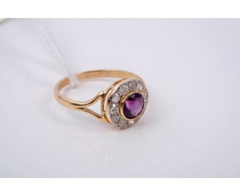 Amethyst and diamond cluster ring with a circular mixed cut amethyst surrounded by old cut and brilliant cut diamonds and spl