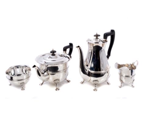 George V four piece silver tea set comprising teapot of cauldron form, with band of raised decoration and shaped flared rim, 