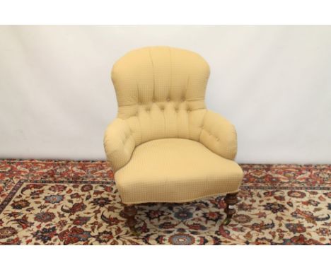 Victorian button back easy chair upholstered in cream spotted material with shaped seat, on turned oak legs terminating on br
