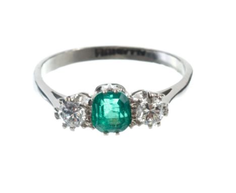 Emerald and diamond three stone ring with a step cut emerald estimated to weigh approximately 0.53 carats, flanked by a brill