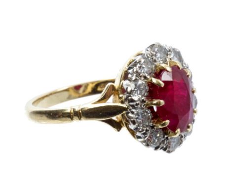 Ruby and diamond cluster ring with an oval mixed cut ruby surrounded by ten brilliant cut diamonds in claw setting on gold (1