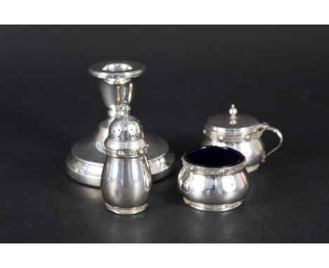 A silver three piece condiment set with Celtic band decoration by Goldsmiths together with a silver candlestick, weight appro