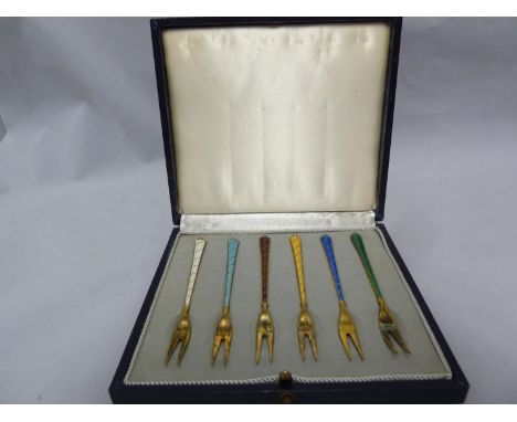 A cased set of Danish Sterling silver gilded and enamelled olive forks, each of two tines on engine turned and 'twist' effect