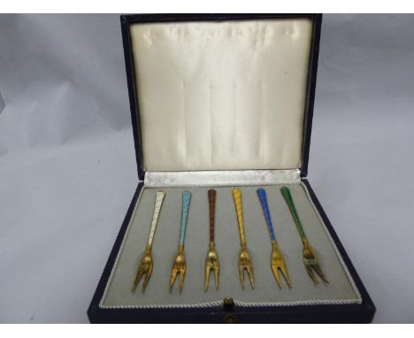 A cased set of Danish Sterling silver gilded and enamelled olive forks, each of two tines on engine turned and 'twist' effect