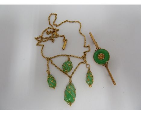A Chinese jade and 14ct yellow gold bar brooch, a circular Chinese lucky symbol within a ring of green jade, 6cm long, 3.4grm