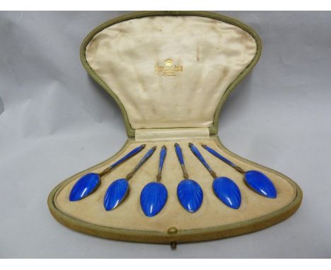 A cased set of six silver and enamelled coffee spoons, the engine turned shell back bowl on enamelled fluted baluster handles