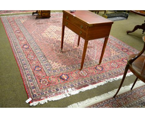 Tabriz design carpet the Herati field centred by an ivory medallion framed by spandrels and samovar motif borders, 367cm by 2