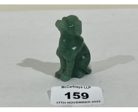 A carved jade seated dog. 2' high