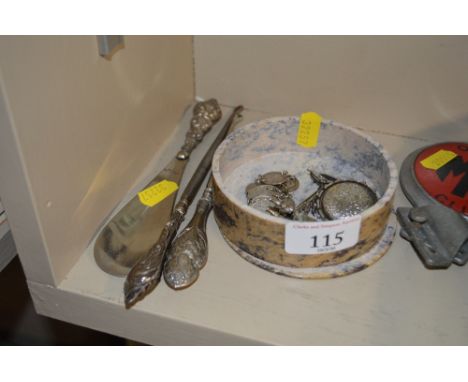 A small circular hard stone box and cover containing various silver items; two silver handled button hooks and a silver handl