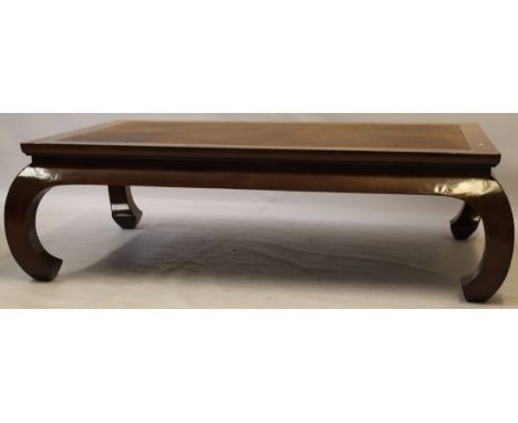 A contemporary Chinese hardwood low 'kang' table
The woven and lacquered top surrounded by mitred supports extending to a swe