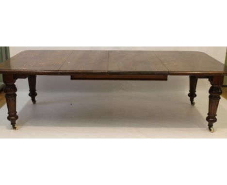A Victorian oak wind action extending dining table, two leaves and winder
The rectangular form with rounded corners and mould