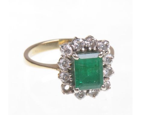 A yellow gold diamond and emerald cluster ring
The central facet cut emerald approx 7x5mm, surrounded by a row of small diamo