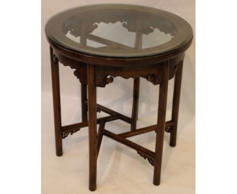 A contemporary Chinese huanghuali style occasional table
The circular topped table united by a hexagonal central roundel issu