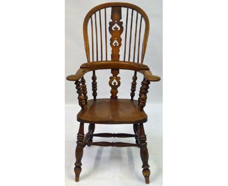 A late Victorian/Edwardian elm and beech comb back Windsor chair
The pierced splat back flanked by scrolling arms and bobbin 