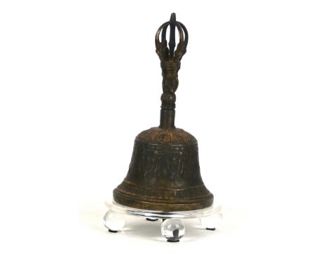 A Tibetan hand held temple bell Of typical conical form, cast with swags and figural designs, the handle formed with bodhisat