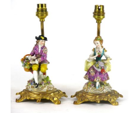 A pair of late 19th century hard paste porcelain table lamps
Depicting a gentleman and lady seated surrounded by floral encru