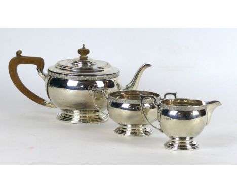 A George VI hallmarked silver three piece tea service
Comprising teapot, twin handled sugar bowl, milk jug, each having a cas