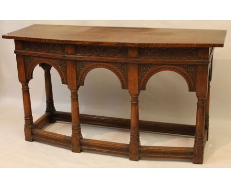 A 17th Century style carved solid oak sideboard, 20th Century
The shaped front featuring a guilloche carved frieze above thre