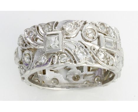 An Art Deco design diamond eternity ring
The white gold band shaped and pierced in stylised foliate form and mounted with gra