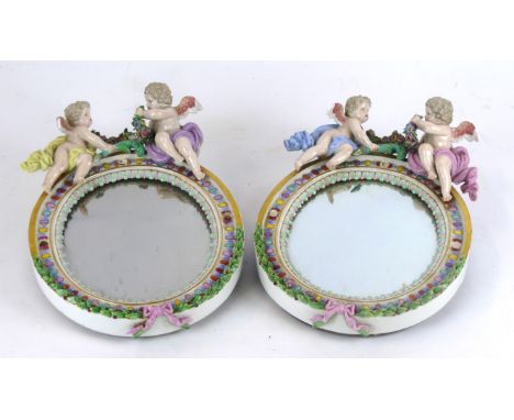 A pair of 19th Century Meissen hard paste porcelain oval dressing table mirrors
Each surmounted by two cherubs and decorated 