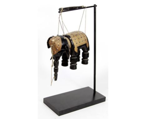 A Burmese yoke thè elephant puppet The jointed black lacquered elephant adorned with a gilt and jewelled saddle and head piec