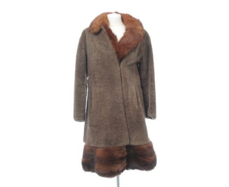 A 1960s lambswood and fox fur three-quarter length swing coat
The light brown lambswool coat adorned with a red fox detachabl