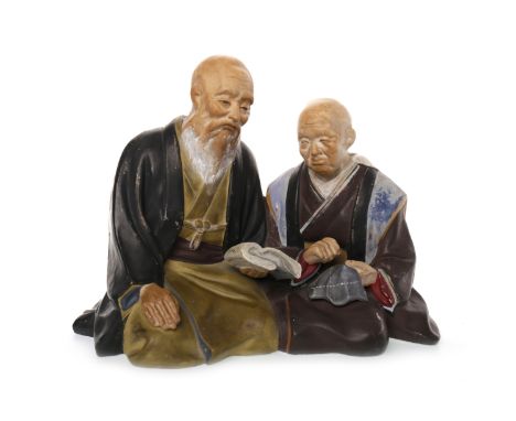 MID 20TH CENTURY JAPANESE CERAMIC FIGURE GROUPmodelled as two kneeling, reading men, 23cm long 