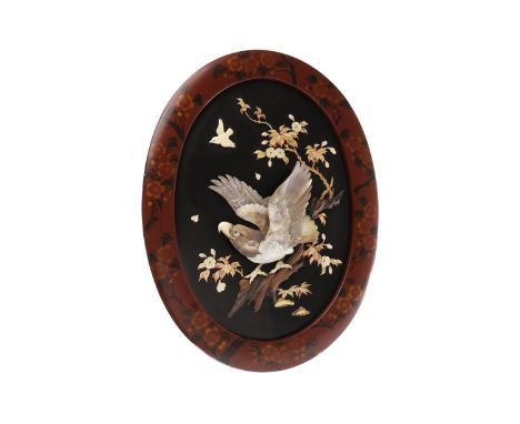 PAIR OF EARLY 20TH CENTURY JAPANESE OVAL LACQUERED PANELSdecorated with single birds of prey in high relief in carved bone an