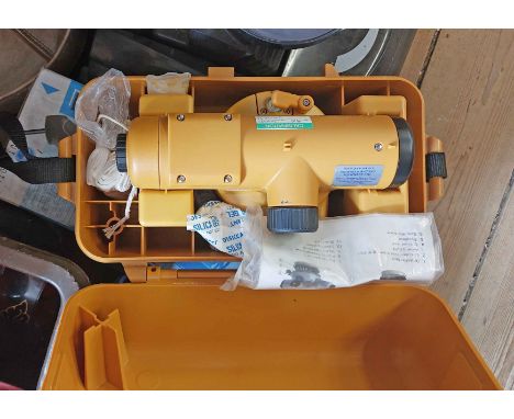 A Topcon AT-G7 theodolite in plastic carry case - sold with a metal tripod, nine ranging poles, levels and a 5m staff