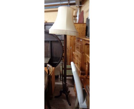 A vintage mahogany standard lamp with fluted columns, set on tripod base. with shade