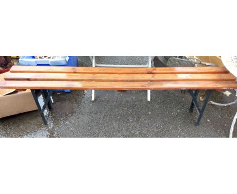 A folding slatted trestle bench