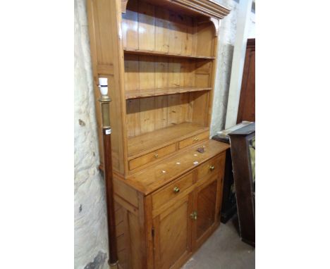 A 1.08m vintage polished pine two part dresser with two shelf open plate rack, cup hooks and two drawers under, set on a base