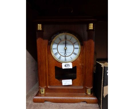A Seiko modern polished wood cased bracket timepiece with visible pendulum and battery movement