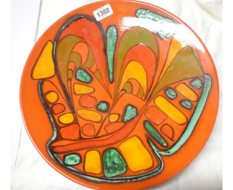 A large vintage Poole Pottery Delphis charger with brightly coloured abstract decoration on an orange ground