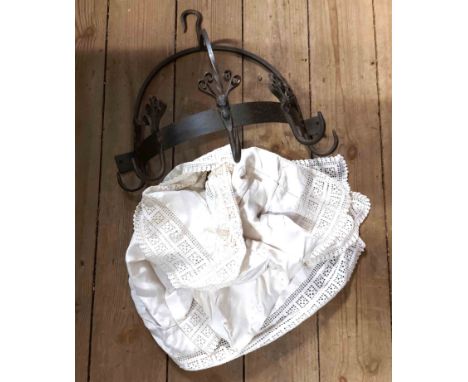 A bag containing wrought iron pot hanger - sold with an old linen tablecloth with crochet edge