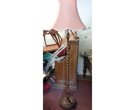 A vintage polished oak standard lamp with barley twist pillar and circular base, with shade