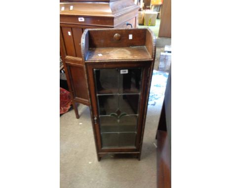 A 35cm early 20th Century polished oak book cabinet with shelves enclosed by a decorative leaded glazed panel door, set on br