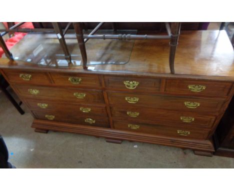 A 1.47m modern Eastern hardwood chest with an array of ten drawers, set on heavy bracket feet