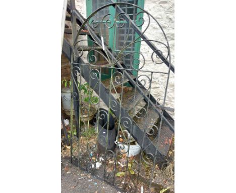A wrought iron garden gate with arched top