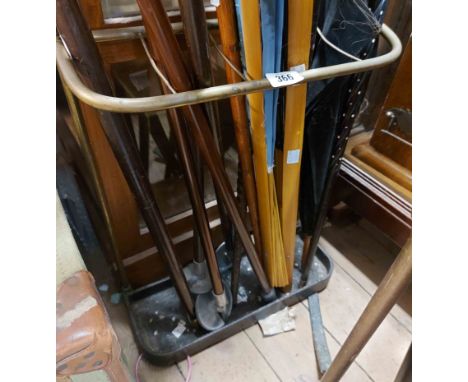 A vintage brass stick stand with black painted cast iron base