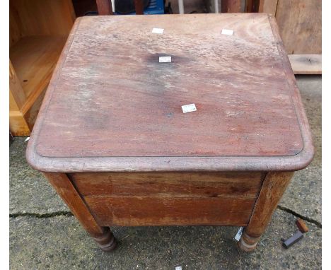 A wooden commode with ceramic liner and wooden lid