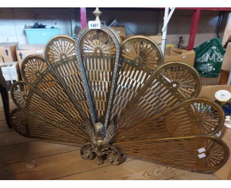 A vintage cast and cut brass peacock pattern fire guard