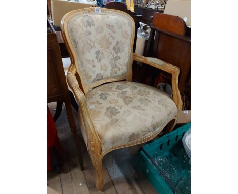 A Stuart Jones blonde wood framed panel back elbow chair with machine tapestry upholstery, set on cabriole front legs