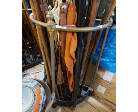 A vintage brass demi-lune stick stand with black painted cast iron base