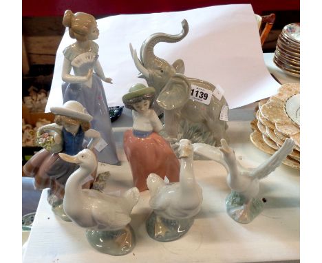 A Lladro porcelain figurine, depicting a goose with extended wings, two similar Nao geese figurines and an elephant - sold wi