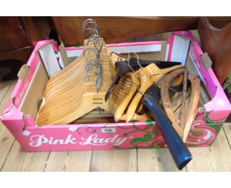 A box containing a collection of vintage wooden coat hangers including two branded examples