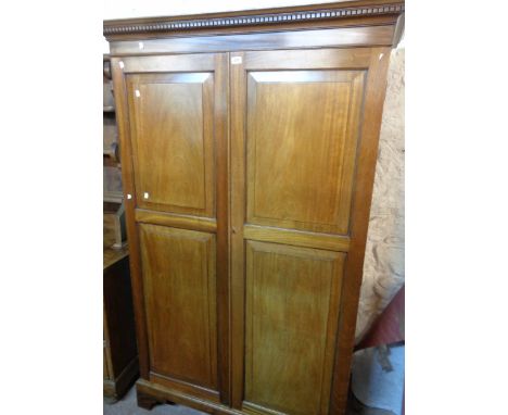 A 1.24m Victorian mahogany double wardrobe with dentil cornice and hanging space enclosed by a pair of panelled cupboard door