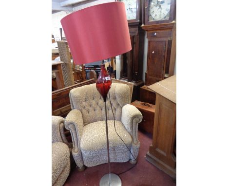 A retro style designer lamp standard with blown cranberry glass form on chrome plated pillar and circular base - with shade