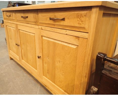 Light oak sideboard with three drawers over three cupboards
